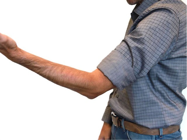Mann zeigt wie man sich den Hemdärmel im Casual Look krempelt.