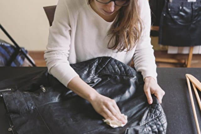 Frau pflegt eine Lederjacke