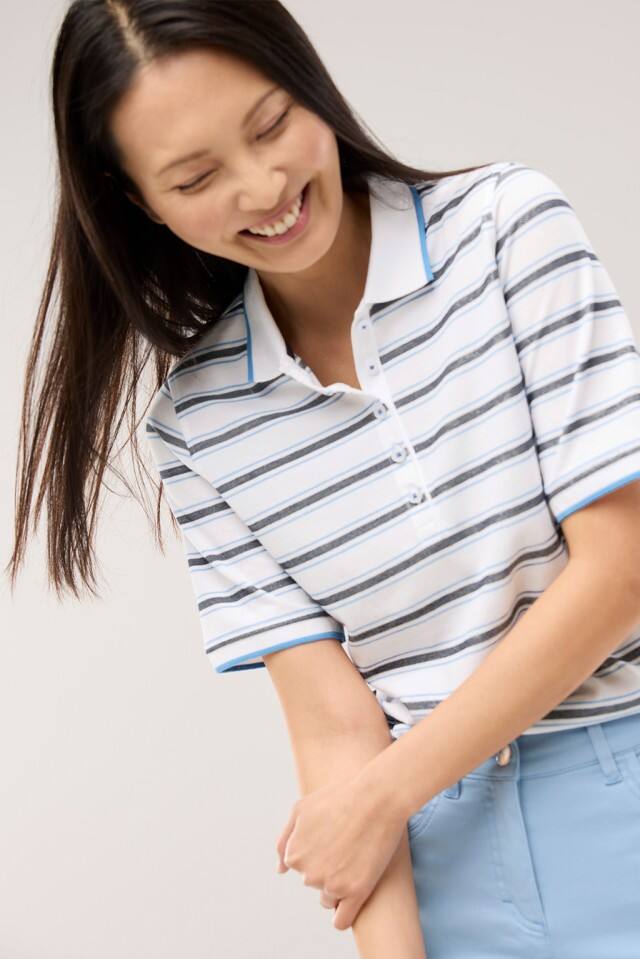 Eine Frau trägt ein Extraglatt Polo mit Streifen in Meerblau.