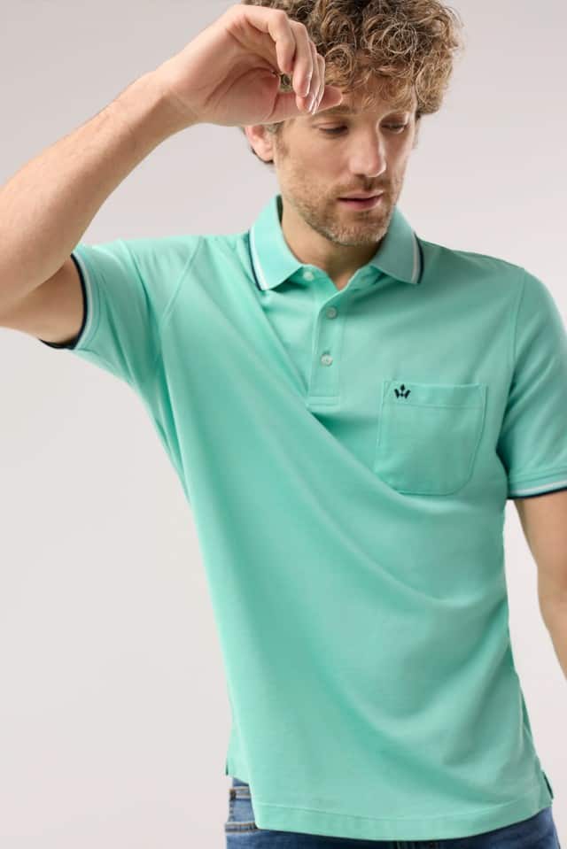 Ein Mann trägt ein Extraglatt-Polo Bicolor in Uni-Mint.