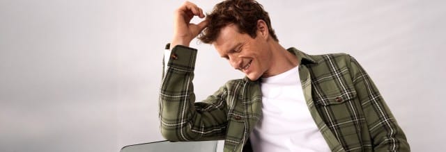 Ein Mann trägt eine Karo Overshirt und darunter ein weißes Shirt.