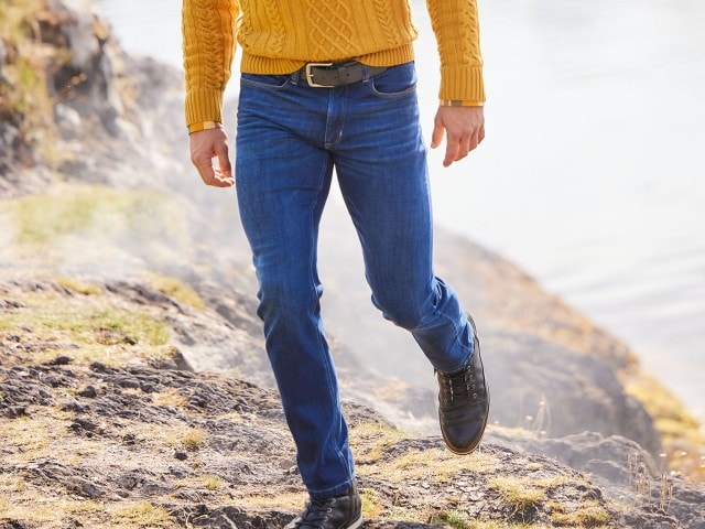 Mann trägt eine dunkelblaue Jeans im Gebirge