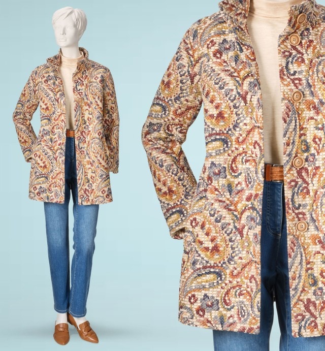 Eine Schaufensterpuppe trägt eine bunte gemusterte Jacke im Paisley-Stil über einem beigen Oberteil. Dazu kombiniert sind eine blaue Jeans und braune Slipper für einen eleganten, aber alltagstauglichen Look.