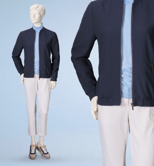 Eine Schaufensterpuppe trägt eine dunkelblaue Jacke über einem hellblauen Pullover. Dazu kombiniert sind helle Hosen und sportliche Sneakers für einen lässig-modernen Look.