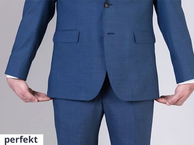 Mann trägt einen blauen Anzug und hält die Hände am Ende des Sakkos.