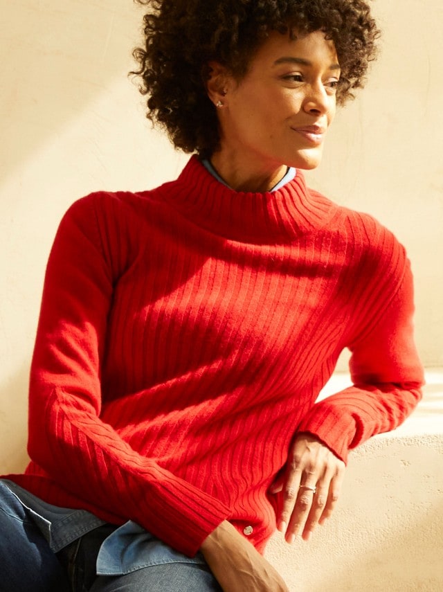 Frau trägt einen weichen orangenen Cashmere Pullover.