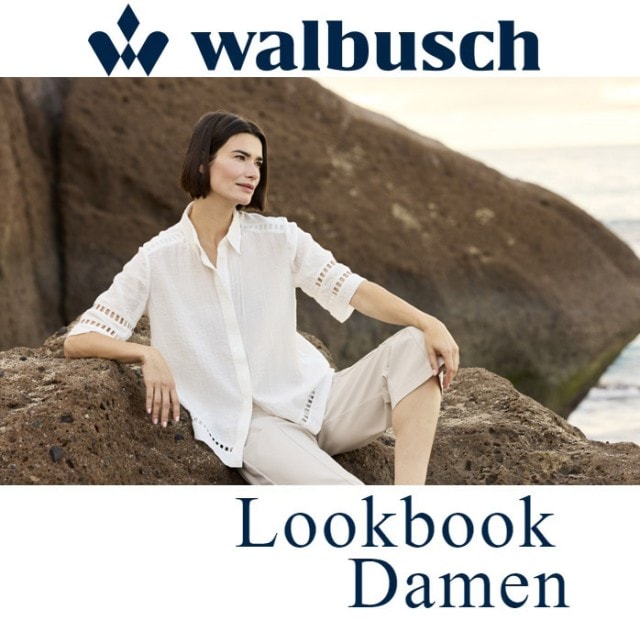 Ein Walbusch Damen Model mit weißer Bluse sitzt bei einem Fotoshooting auf ein Paar Steinen