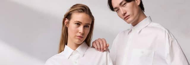 Ein Mann und eine Frau stehen nebeneinander und tragen beide weiße Hemden. Ein Mann und eine Frau stehen nebeneinander und tragen beide weiße Hemden.