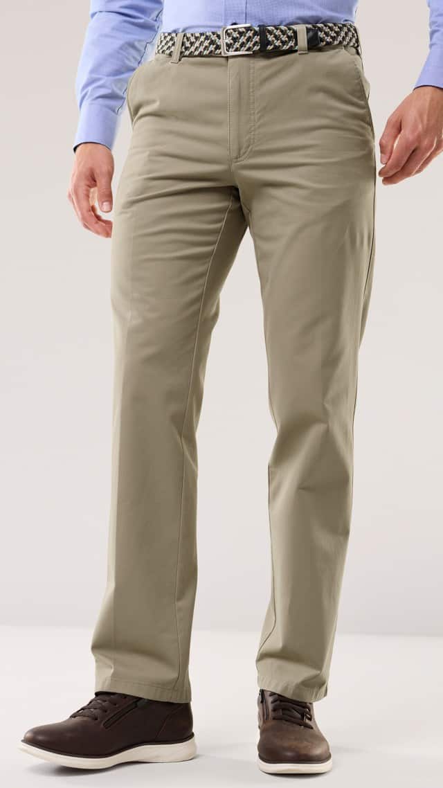 Ein Mann trägt eine beige Stoffhose mit geflochtenem Gürtel, hellblauem Hemd und braunen Lederschuhen. Der Look ist klassisch und gepflegt, passend für Büro oder Freizeit.