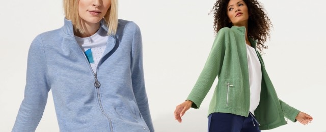 Zwei Frauen tragen sportliche Jacken: eine in Hellblau mit Reißverschluss und eine in Hellgrün mit Strukturmuster und Zipper-Details. Die Outfits wirken leger und eignen sich ideal für Freizeit oder Outdoor-Aktivitäten.