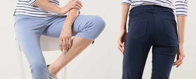 Zwei Frauen tragen schmale Hosen: eine in Hellblau, die andere in Dunkelblau. Beide kombinieren die Hosen mit gestreiften Oberteilen für einen lässigen, maritim inspirierten Look.