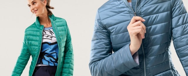 Zwei Frauen tragen gesteppten Steppjacken: eine in Grün, kombiniert mit einem gemusterten Shirt, und eine in Hellblau. Die Jacken wirken sportlich und eignen sich gut für die Übergangszeit.