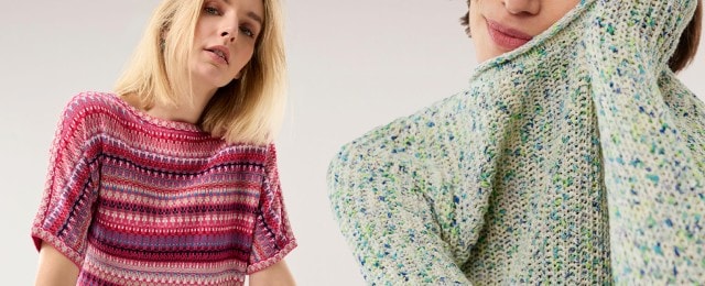 Zwei Frauen zeigen farbenfrohe Strickpullover: Eine trägt ein kurzärmliges Modell mit pink-blauem Muster, die andere einen grob gestrickten Pullover in zarten Pastelltönen mit grünen und blauen Akzenten. Die Looks sind modern, gemütlich und ideal für einen frischen Frühlingsstil.