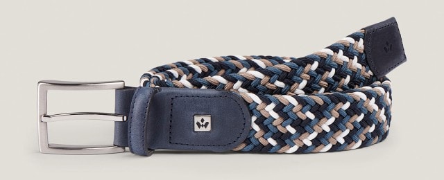 Ein geflochtener Gürtel in Blau, Braun und Weiß mit Metallschließe und Lederdetails. Das Accessoire wirkt modern und vielseitig kombinierbar.