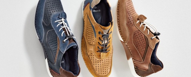 Drei trendige Herren-Sneaker in Blau, Camel und Braun mit modernen Details und sportlichem Schnitt liegen nebeneinander. Die Farbkombinationen, Lochmuster und Kontrastschnürsenkel unterstreichen den modischen, lässigen Fashion-Look.