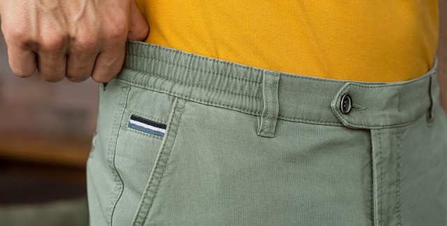 Ein Mann zieht an dem Dehnbund seiner Hose.