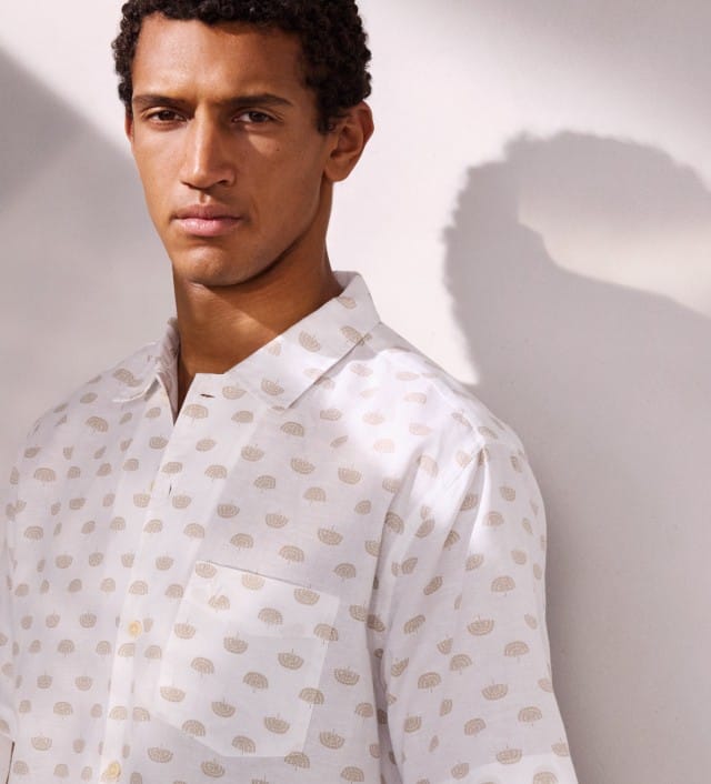 Ein Mann trägt ein weißes Hemd mit Muster.