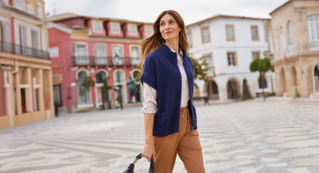 Frau mit blauer Strickjacke und brauner Hose auf Piazza