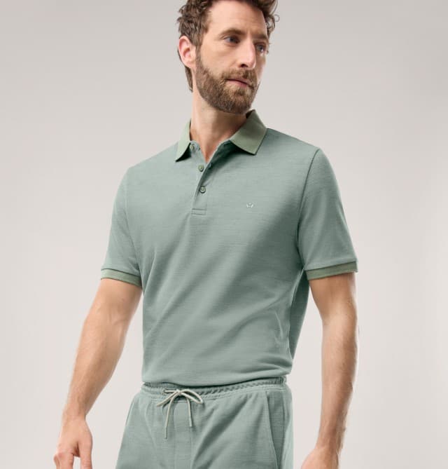 Ein Mann trägt ein grünes Poloshirt mit passender Hose. 