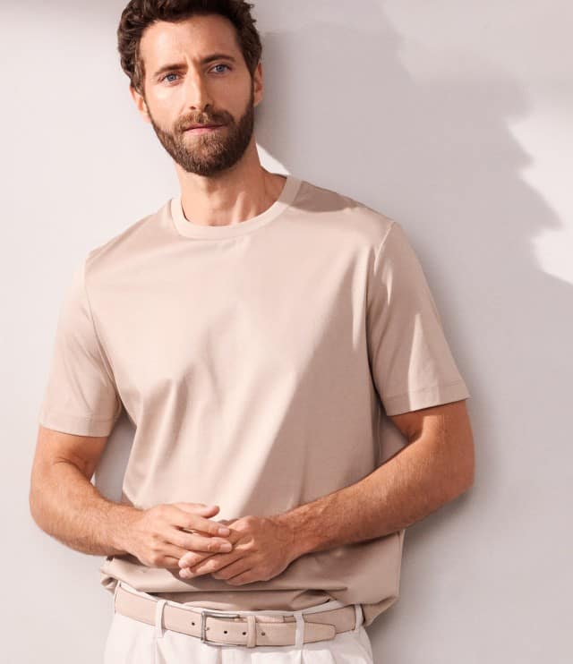 Ein Mann trägt ein T-Shirt in Beige mit passender Hose.