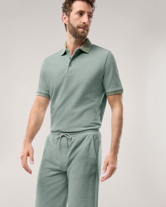 Ein Mann trägt ein grünes Polo-Shirt mit passenden Shorts.
