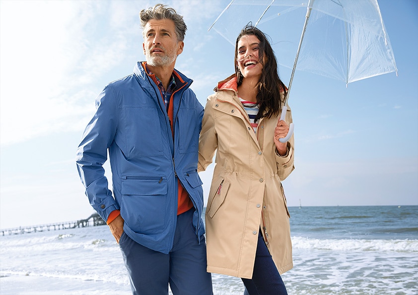 Man und Frau mit Regenschirm am Strand