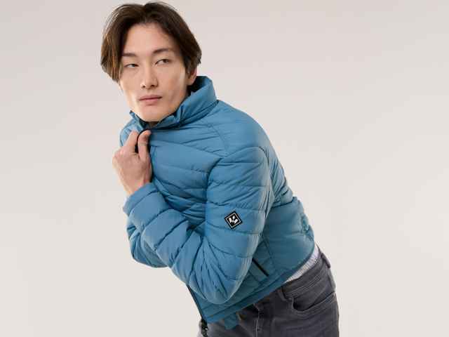 Ein Mann trägt eine Klima Leichtsteppjacke in Rauchblau.