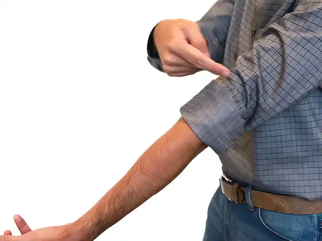 Mann zeigt wie man sich den Hemdärmel im italienischen Look krempelt.