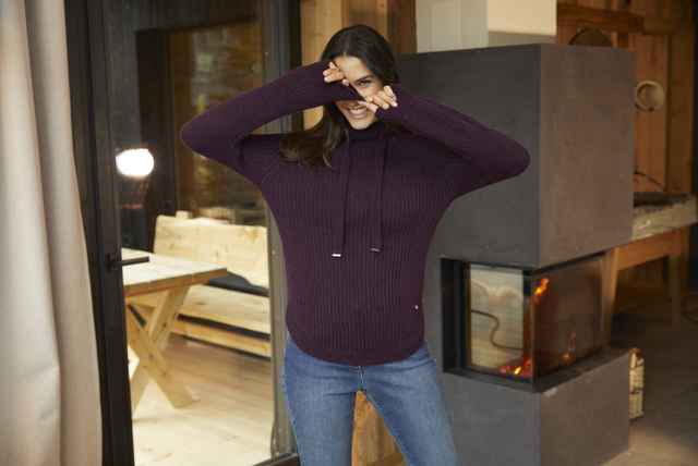 Aufnahme einer Frau in einem roten Merino Pullover.