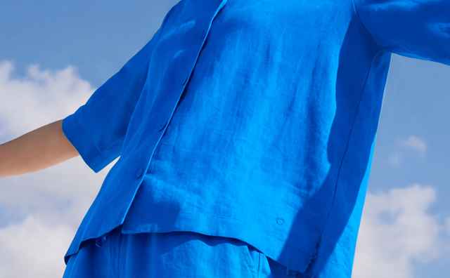 Eine Frau trägt eine Reverskragen Bluse Leinenmix in Königsblau, dazu die passende Hose.