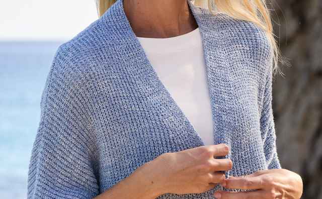 Eine Frau trägt einen Longstrickweste mit Kimonoärmeln in Jeansblau.